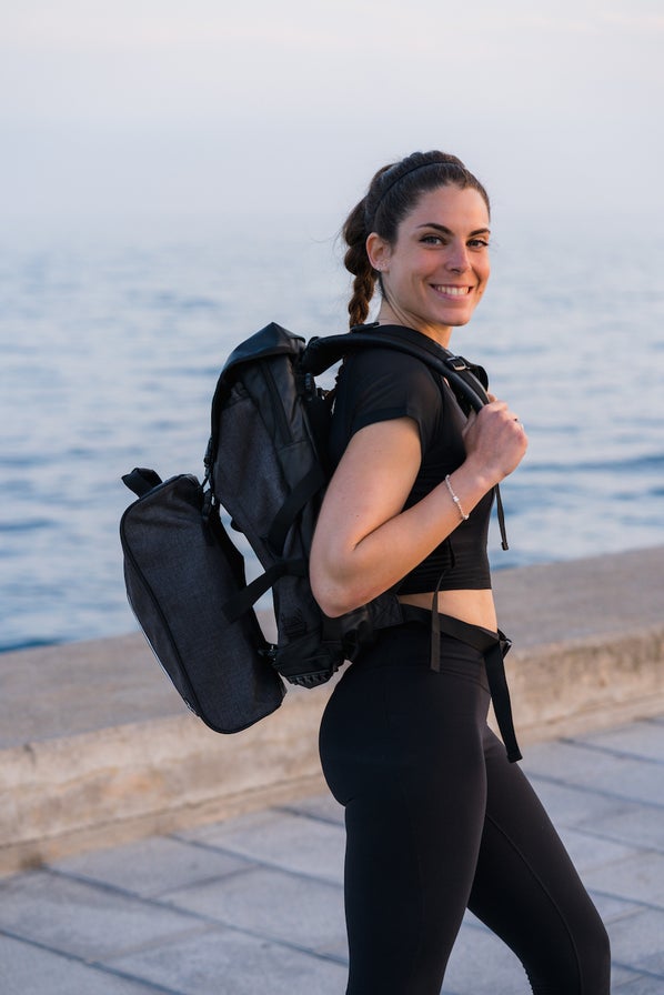 Lady standing with UBC Commuter Backpack with UBC Pod Attachment