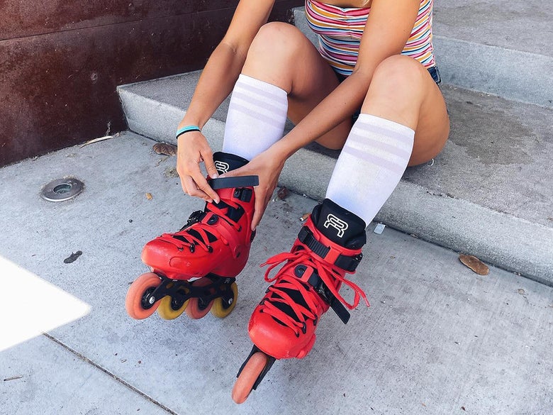 Person lacing up red FR inline skates
