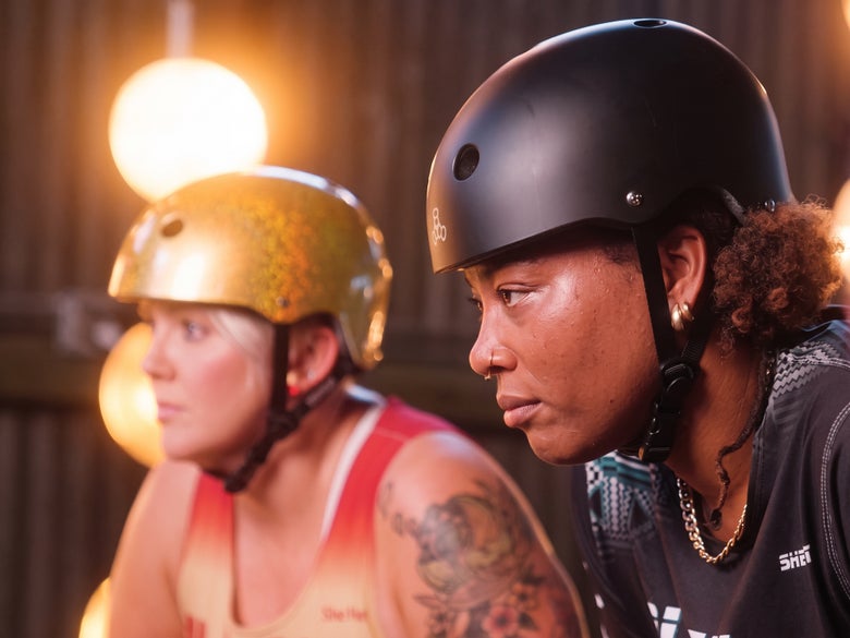 Two roller derby athletes wearing EPS foam helmets
